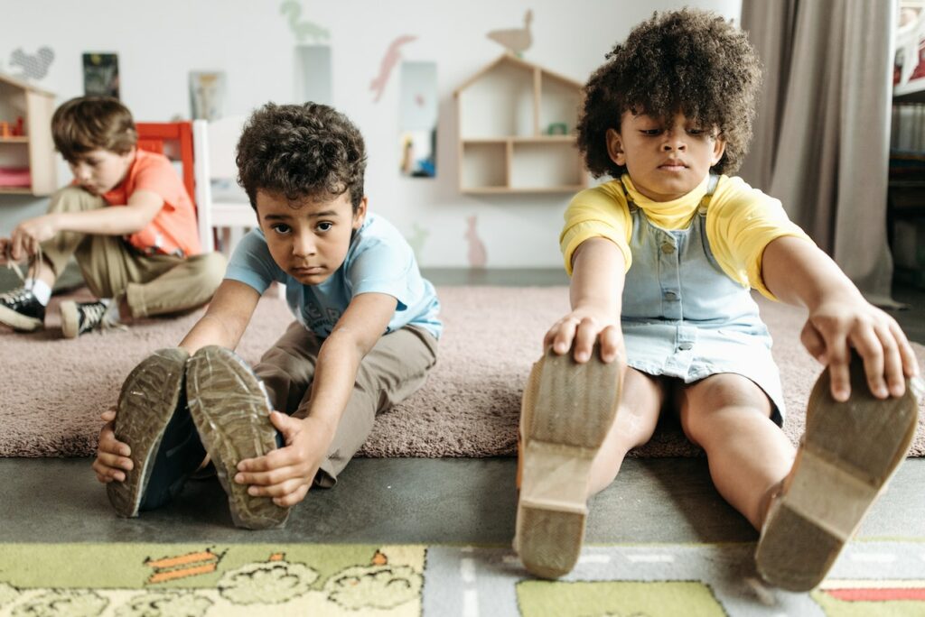 Two young children, boy and girl, stretching in excercise