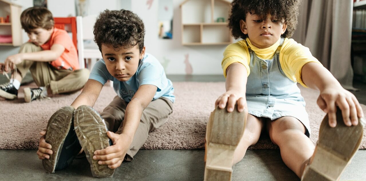 Two young children, boy and girl, stretching in excercise